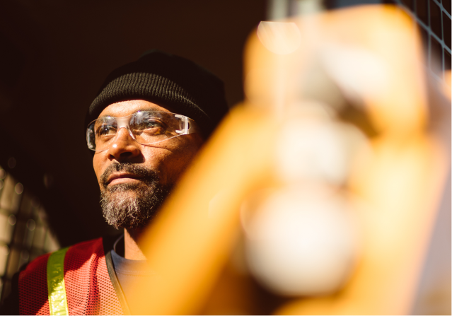 A close-up of a male Foley employee wearing protective glasses.