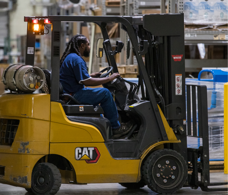 A male Foley employee drives a Caterpillar fork lift truck.