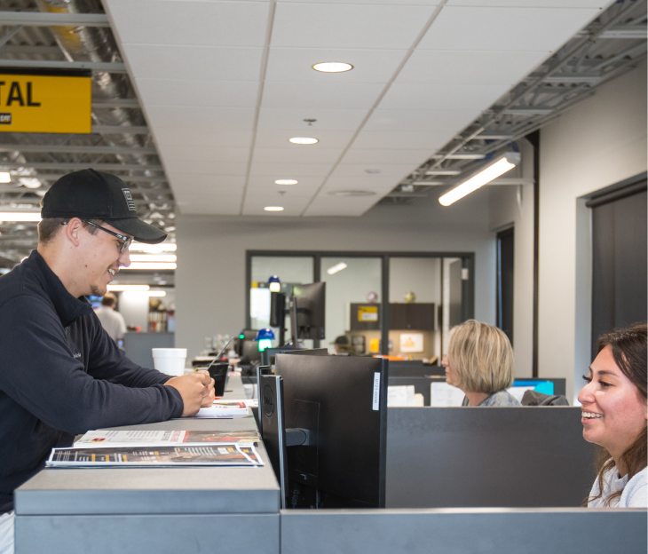 Foley office workers smile and chat with each other as they work.