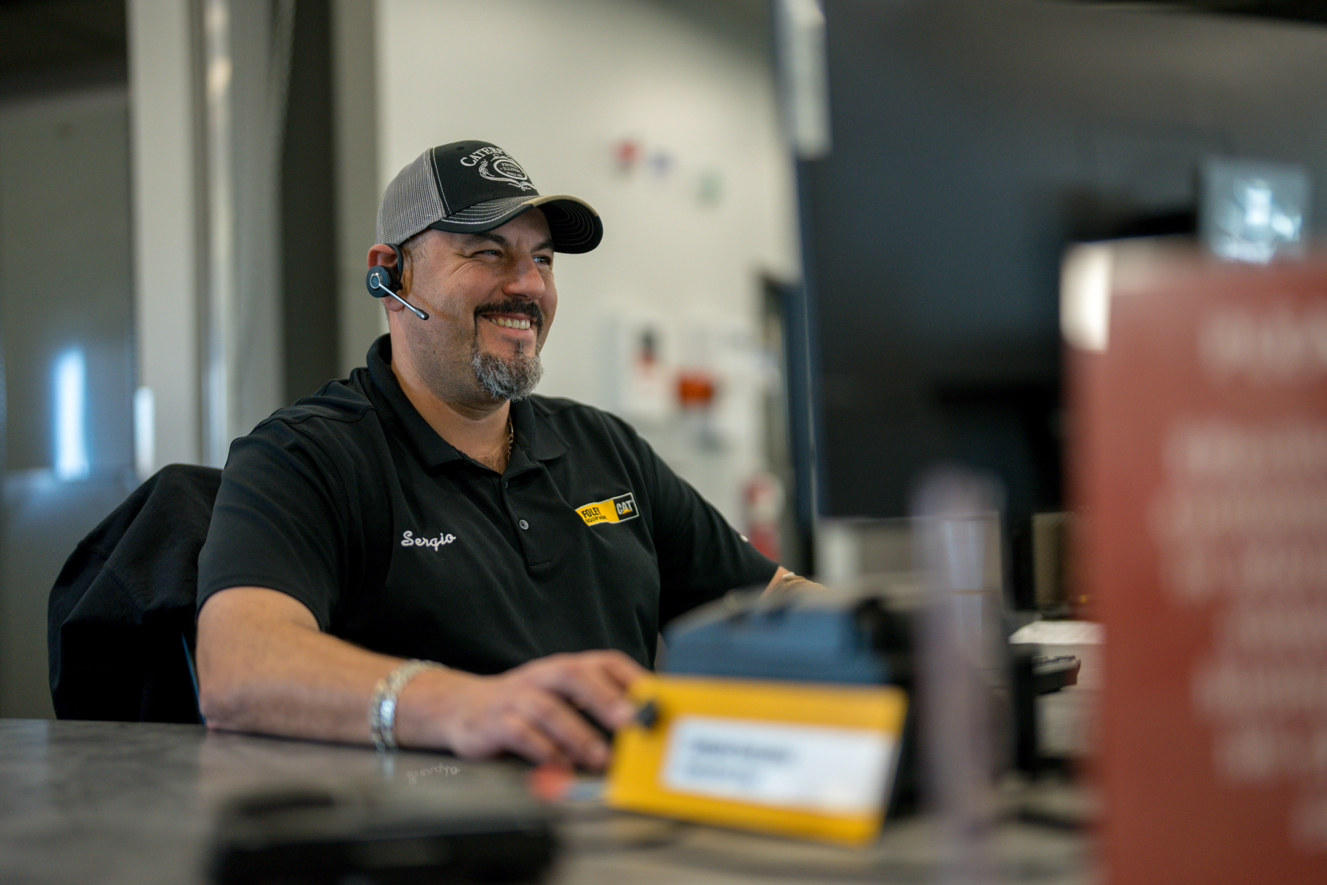 Foley employee working at desk smiling while talking on the phone.