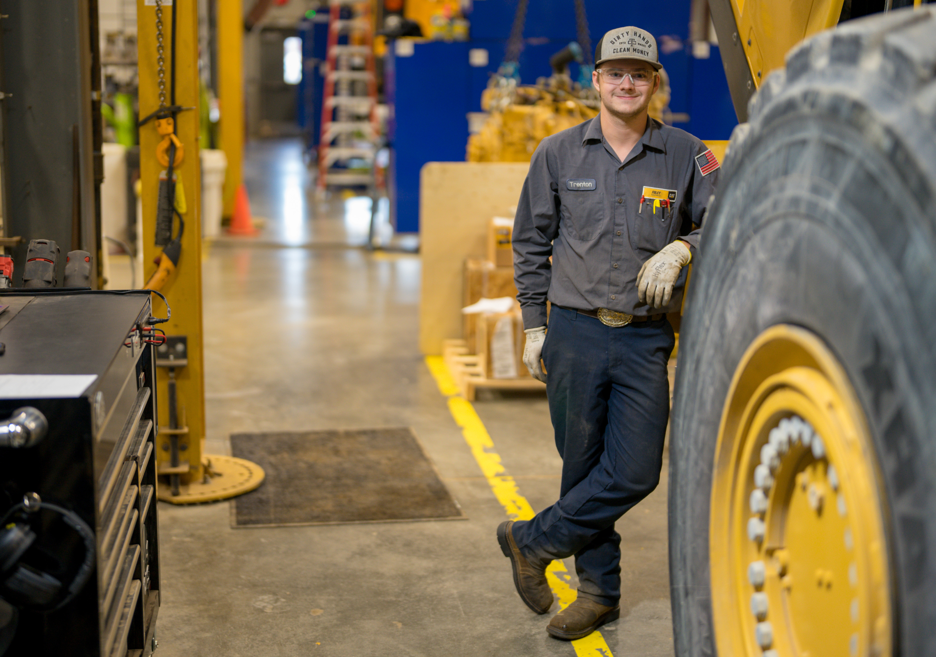 ThinkBIG Intern Technician standing near caterpillar equipment